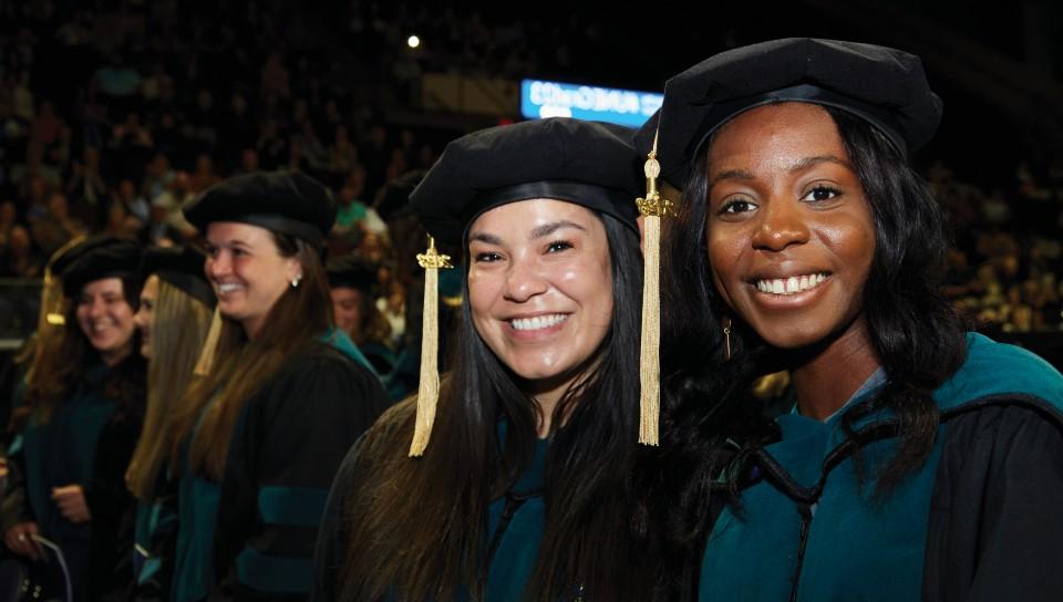 在2023年东北大学毕业典礼上，两名毕业生对着镜头微笑